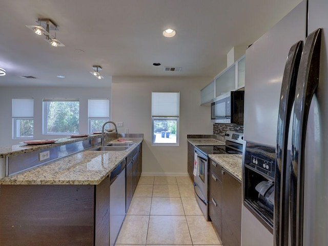 kitchen with tasteful backsplash, a sink, appliances with stainless steel finishes, visible vents, and a peninsula