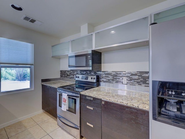 kitchen featuring stainless steel appliances, light tile patterned floors, visible vents, backsplash, and dark brown cabinets