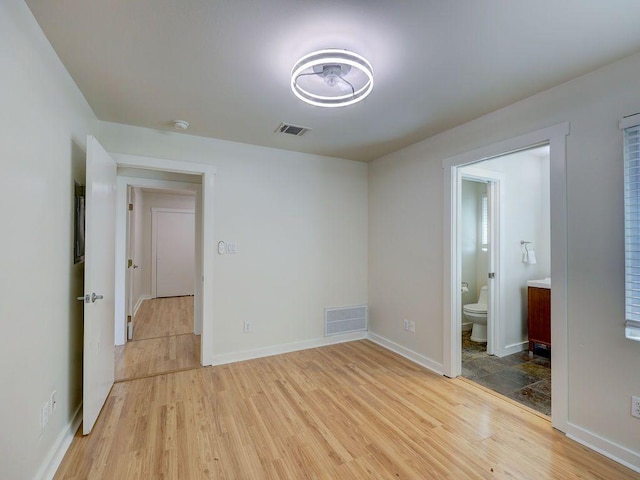spare room with visible vents, baseboards, and light wood-style floors