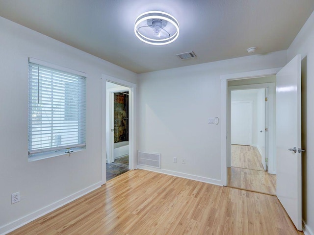 unfurnished room featuring visible vents, baseboards, and light wood-style floors