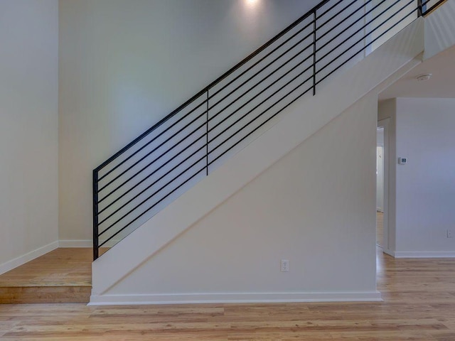 stairs featuring wood finished floors and baseboards