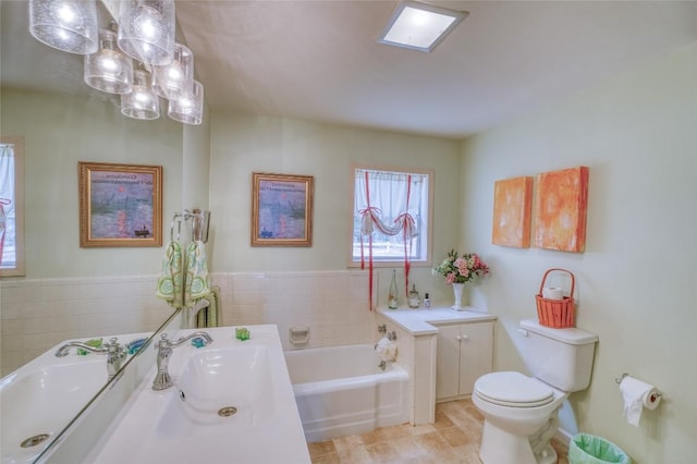 1833 Highland Dr, Marble Falls, TX 78654 - full bath featuring toilet, an inviting chandelier, a garden tub, and a sink
