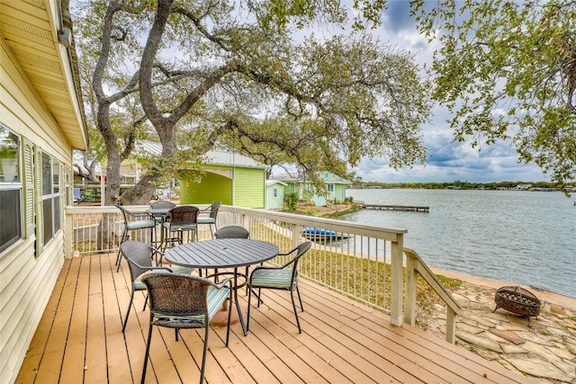 1833 Highland Dr, Marble Falls, TX 78654 - wooden deck featuring a fire pit, a water view, and outdoor dining space