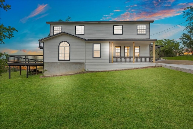 rear view of property with a porch, a wooden deck, and a yard