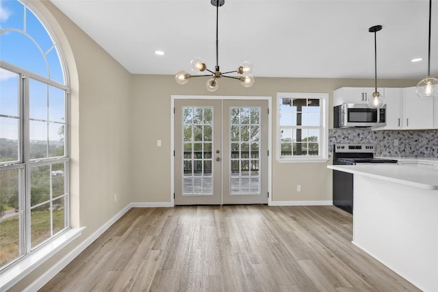 kitchen with light wood finished floors, light countertops, stainless steel appliances, and plenty of natural light