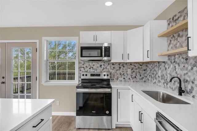 510 Circle Rd, Horseshoe Bay, TX 78657 - kitchen with stainless steel appliances, open shelves, light countertops, decorative backsplash, and white cabinetry