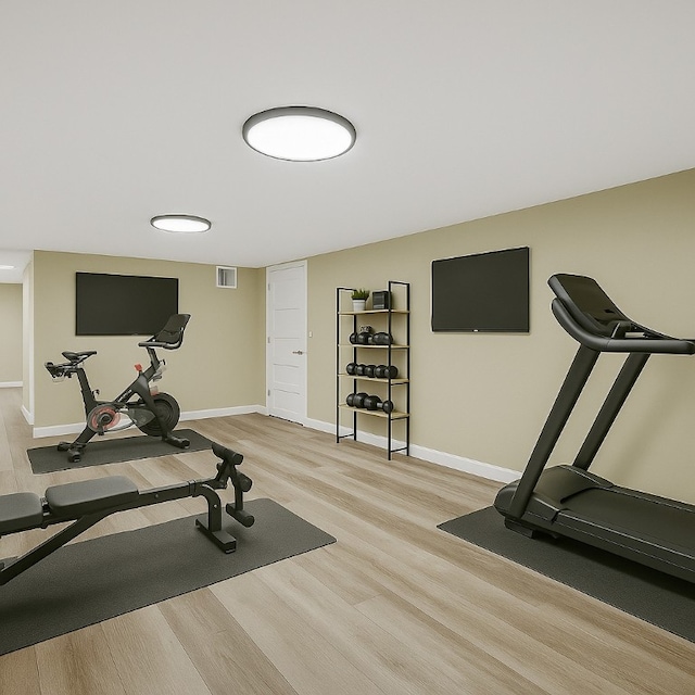 exercise room with visible vents, light wood-type flooring, and baseboards