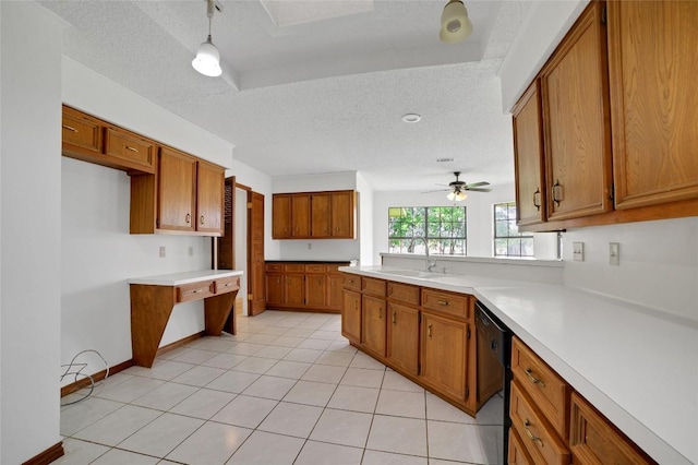 kitchen featuring black dishwasher, light countertops, brown cabinets, a sink, and a textured ceiling