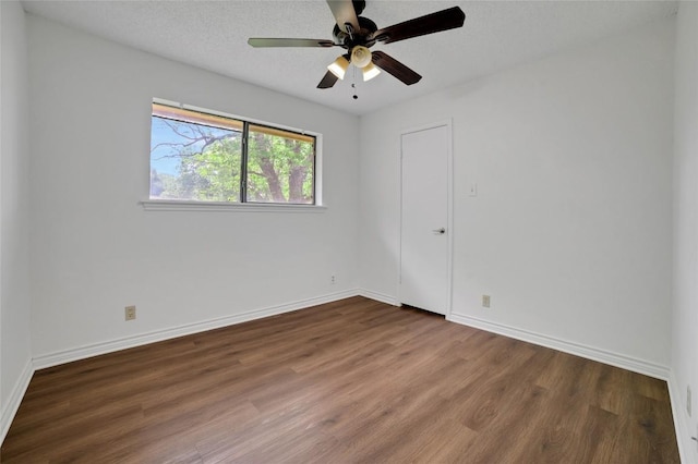 spare room with baseboards, wood finished floors, and ceiling fan
