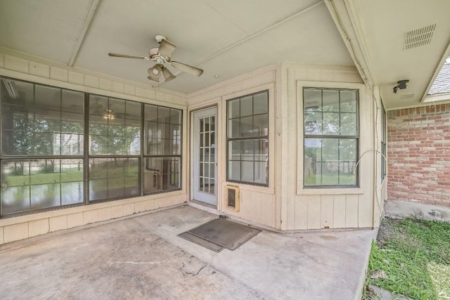 entrance to property with visible vents, ceiling fan, and brick siding
