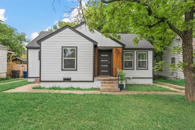 view of front of property featuring a front lawn, board and batten siding, and roof with shingles