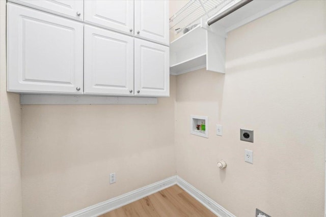 231 Skinner, Kyle, TX 78640 - washroom with hookup for an electric dryer, baseboards, light wood-type flooring, washer hookup, and cabinet space