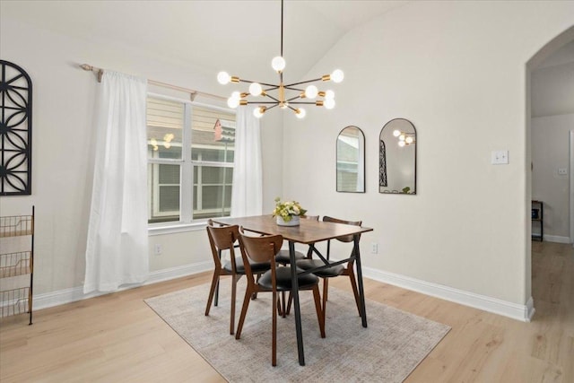 231 Skinner, Kyle, TX 78640 - dining space featuring arched walkways, light wood-style flooring, lofted ceiling, a chandelier, and baseboards