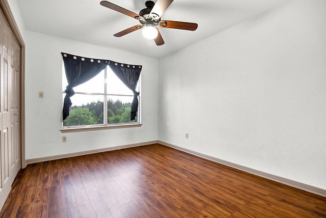 unfurnished bedroom featuring a closet, a ceiling fan, wood finished floors, and baseboards