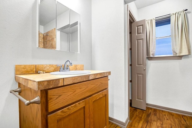 bathroom with vanity, wood finished floors, and baseboards