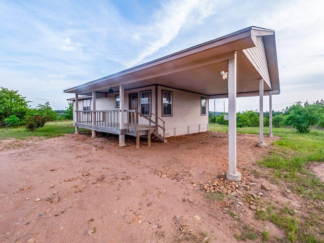 view of front facade with an attached carport and dirt driveway
