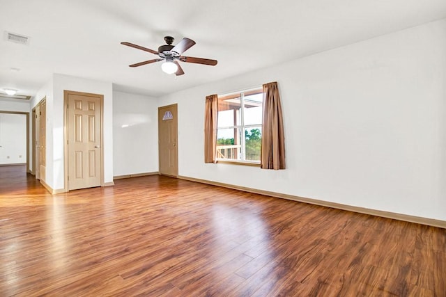 spare room featuring baseboards, visible vents, wood finished floors, and ceiling fan