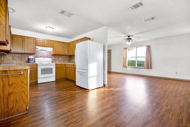 kitchen featuring visible vents, white appliances, under cabinet range hood, and a sink