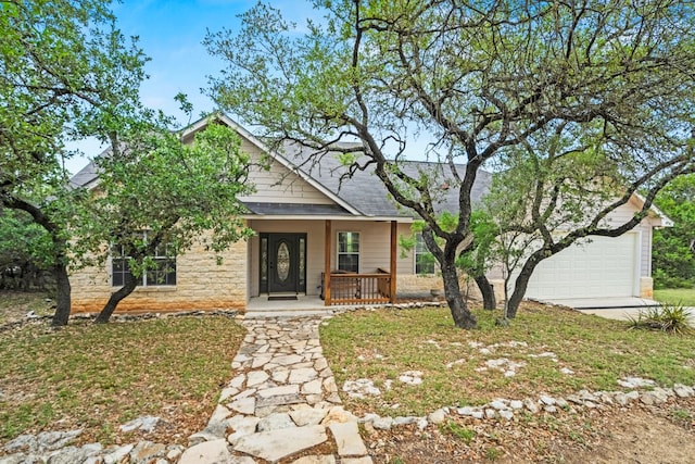 view of front facade with covered porch, a shingled roof, and stone siding