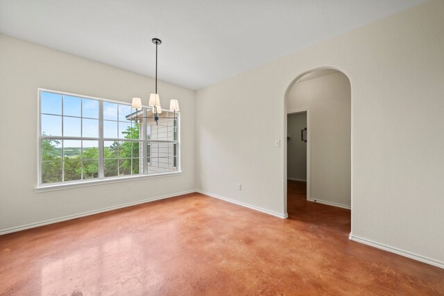 unfurnished room featuring baseboards, arched walkways, a notable chandelier, and finished concrete floors