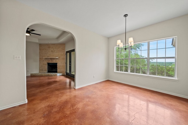 1159 Stallion Springs Dr, Fischer, TX 78623 - unfurnished dining area featuring finished concrete floors, baseboards, a stone fireplace, a chandelier, and ceiling fan