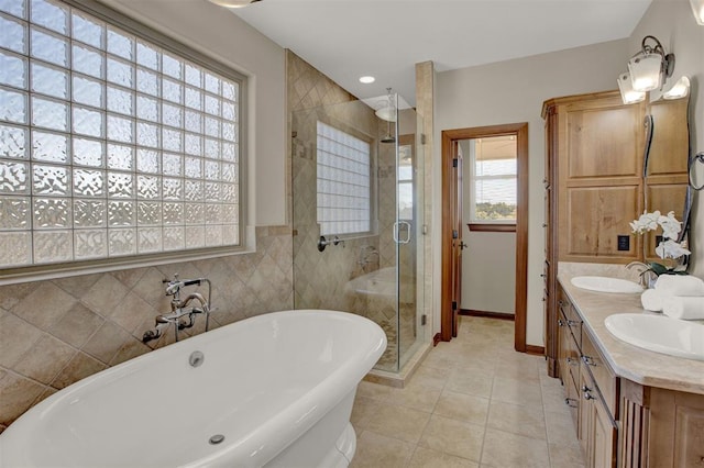 bathroom with a freestanding tub, double vanity, a sink, and a shower stall