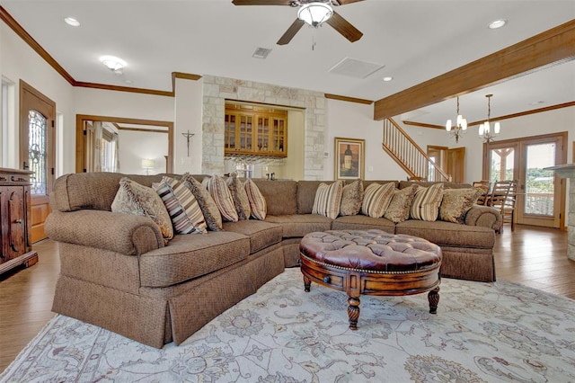 living area with visible vents, wood finished floors, crown molding, and recessed lighting