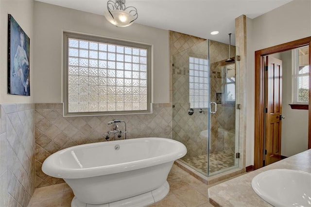 bathroom featuring a shower stall, a sink, tile walls, tile patterned floors, and a freestanding bath