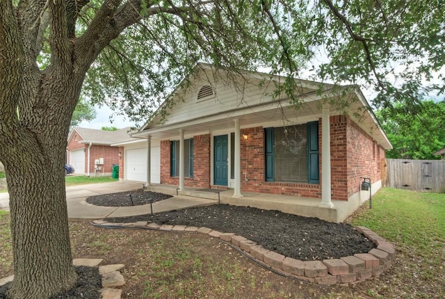 view of front facade with covered porch, brick siding, concrete driveway, an attached garage, and fence