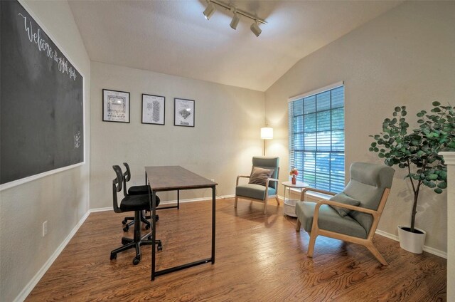 office area featuring track lighting, wood finished floors, lofted ceiling, and baseboards