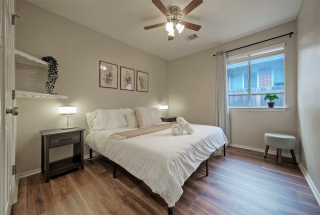 bedroom with baseboards, visible vents, wood finished floors, and a ceiling fan