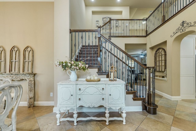 2600 Dalea St, Round Rock, TX 78681 - stairway featuring tile patterned floors, baseboards, arched walkways, and a towering ceiling