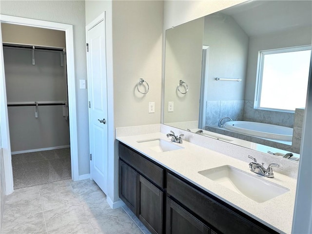 bathroom featuring double vanity, a spacious closet, a bath, and a sink