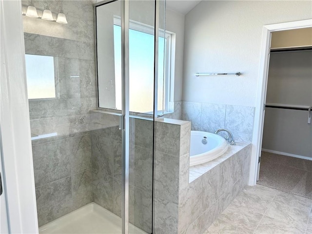 full bath with a garden tub, a stall shower, and a spacious closet