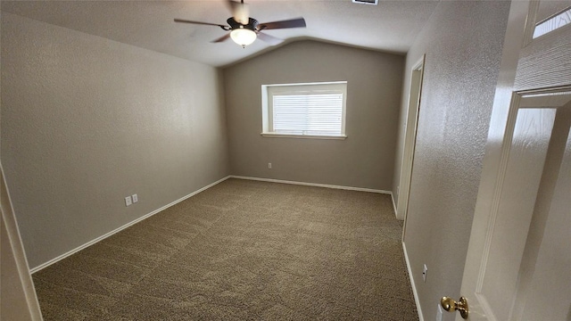 carpeted spare room featuring a textured wall, baseboards, visible vents, a ceiling fan, and lofted ceiling