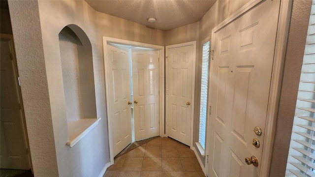 entryway featuring light tile patterned flooring and arched walkways
