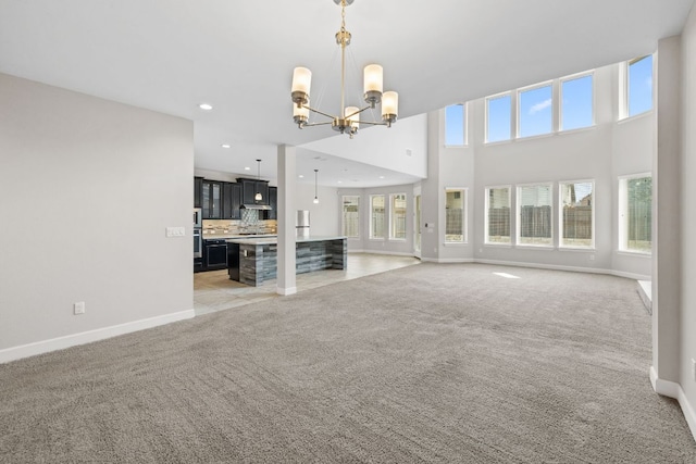 829 Expedition Way, Round Rock, TX 78665 - unfurnished living room with light carpet, a chandelier, recessed lighting, and a towering ceiling