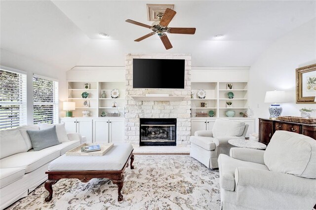 93 Duck Lake Dr, Lakeway, TX 78734 - living room featuring vaulted ceiling, a ceiling fan, a stone fireplace, and built in shelves