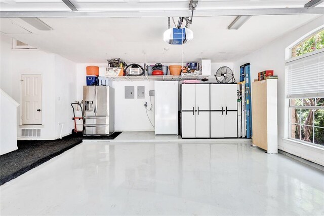 93 Duck Lake Dr, Lakeway, TX 78734 - garage with stainless steel fridge, a garage door opener, and electric panel