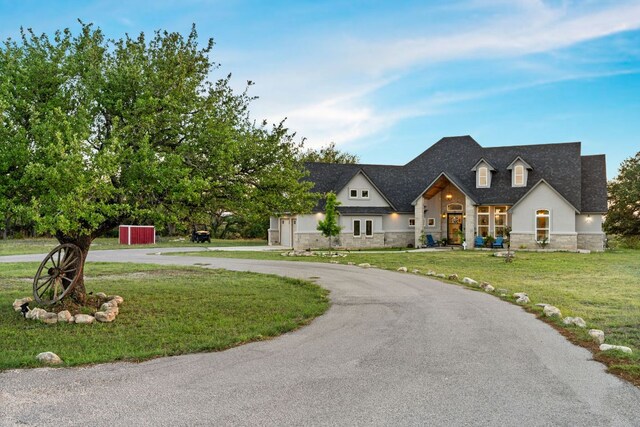 101 Durango Dr, Johnson City, TX 78636 - french country style house featuring a front lawn, stone siding, stucco siding, and curved driveway