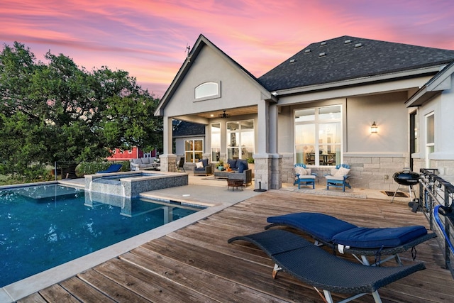 101 Durango Dr, Johnson City, TX 78636 - pool at dusk with outdoor lounge area, a wooden deck, and a pool with connected hot tub