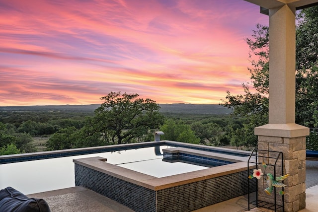 101 Durango Dr, Johnson City, TX 78636 - patio terrace at dusk featuring a wooded view and an in ground hot tub