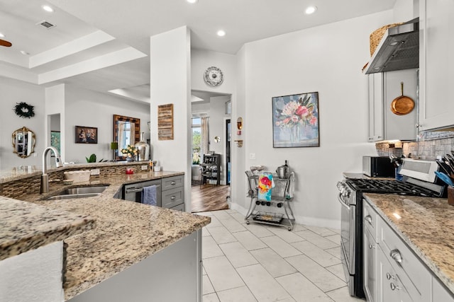 101 Durango Dr, Johnson City, TX 78636 - kitchen featuring stainless steel gas range, light stone countertops, a sink, under cabinet range hood, and backsplash