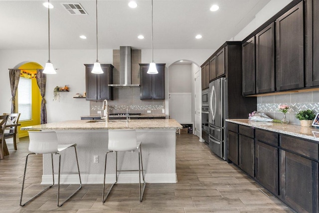 3750 E Palm Valley Blvd Unit 98, Round Rock, TX 78665 - kitchen featuring wall chimney range hood, visible vents, stainless steel appliances, and backsplash