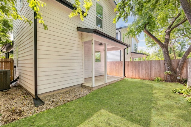 exterior space with fence, a yard, and cooling unit