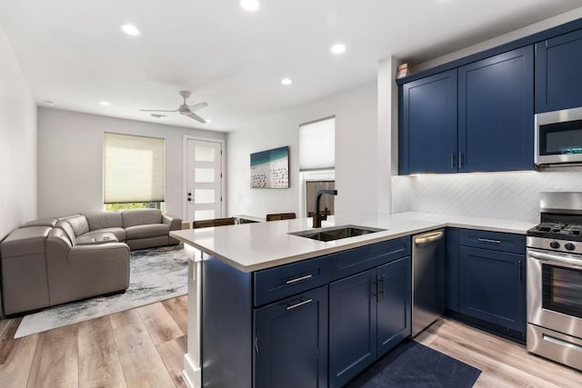 kitchen with a sink, stainless steel appliances, and blue cabinetry