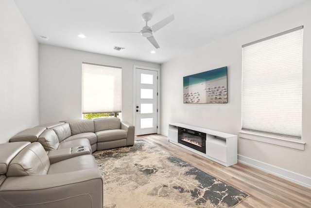 506 Thrasher Ln Unit 2, Austin, TX 78741 - living area featuring a ceiling fan, wood finished floors, a glass covered fireplace, recessed lighting, and baseboards