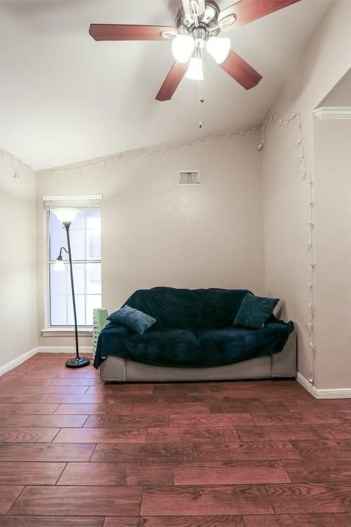 sitting room with visible vents, vaulted ceiling, wood finished floors, and baseboards