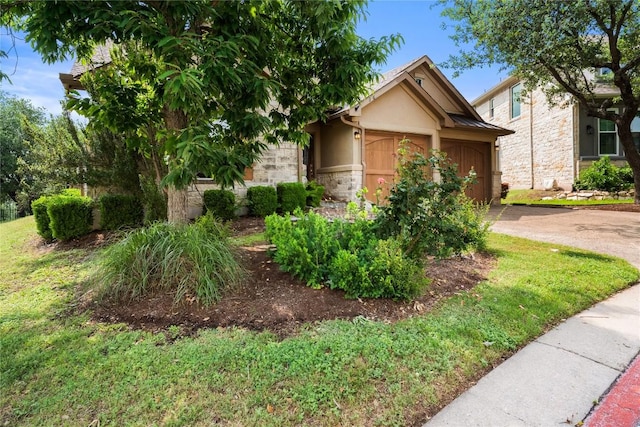 obstructed view of property with stucco siding, a garage, driveway, stone siding, and a front lawn