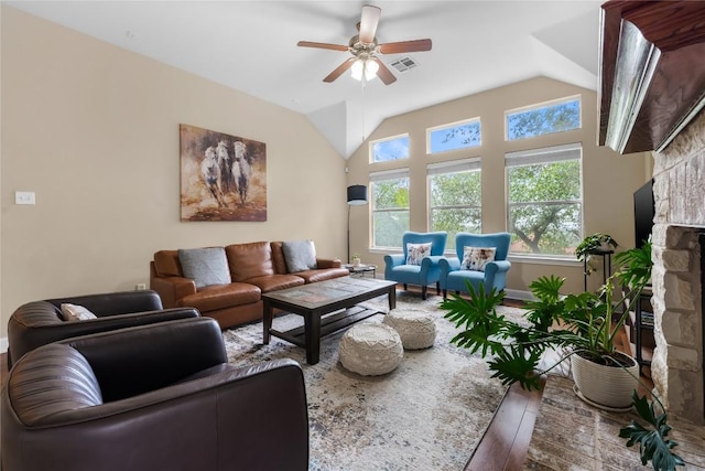 living area with ceiling fan, visible vents, vaulted ceiling, a fireplace, and wood finished floors